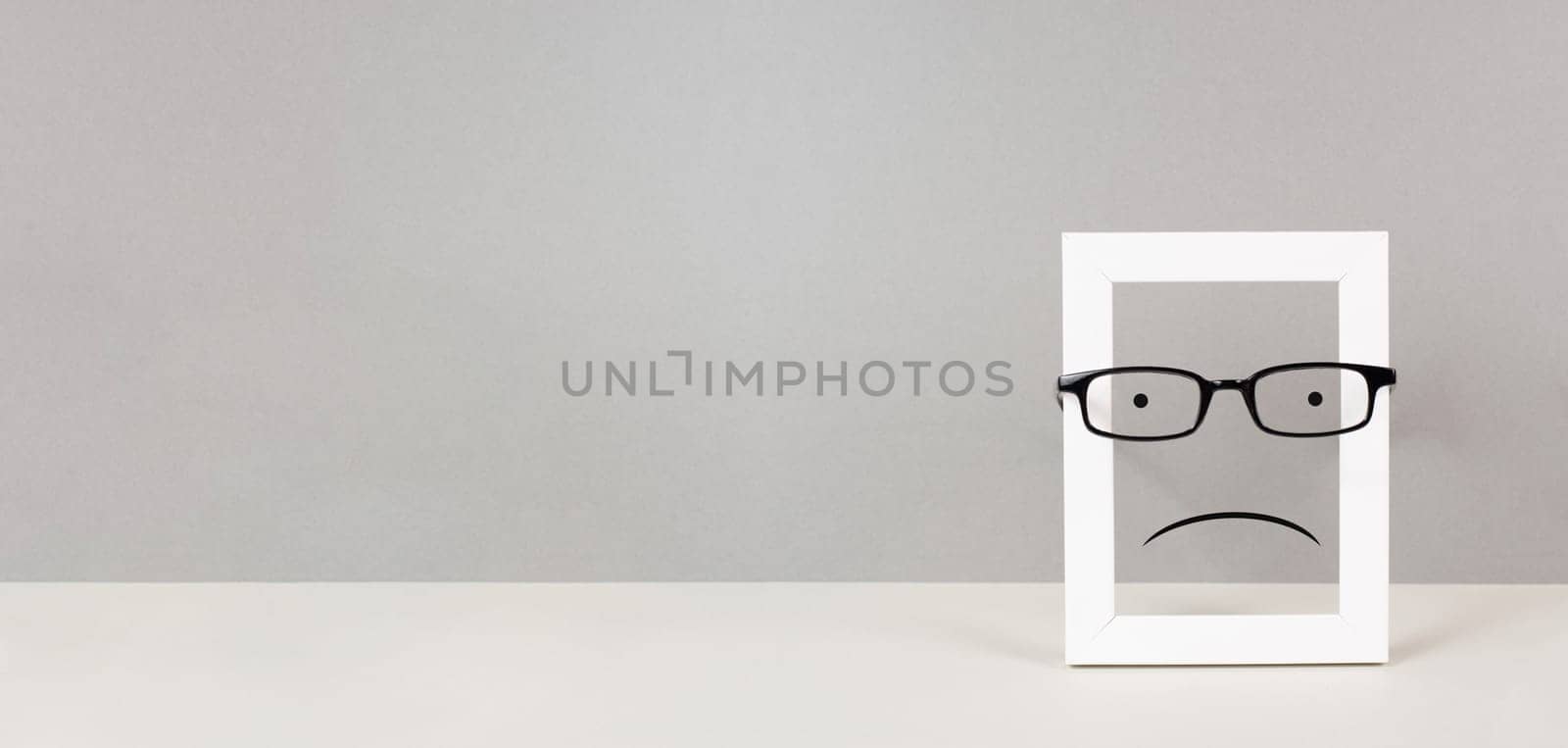 Frame with a sad face, mental health concept, negative mindset, depression, support and evaluation symbol