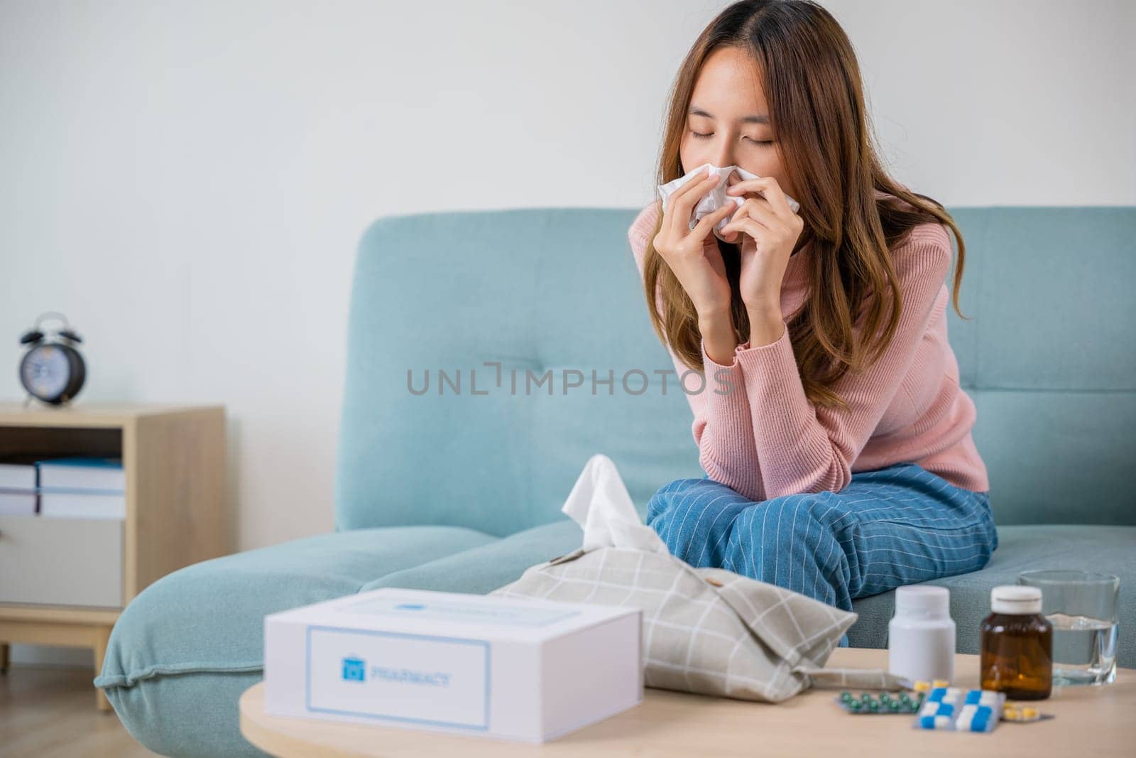 Sick woman. Beautiful female health problem blowing nose use pharmacy kit box delivery service from hospital, delivery pharmacy concept, Asian young girl cold sick she sneeze with tissue paper on sofa