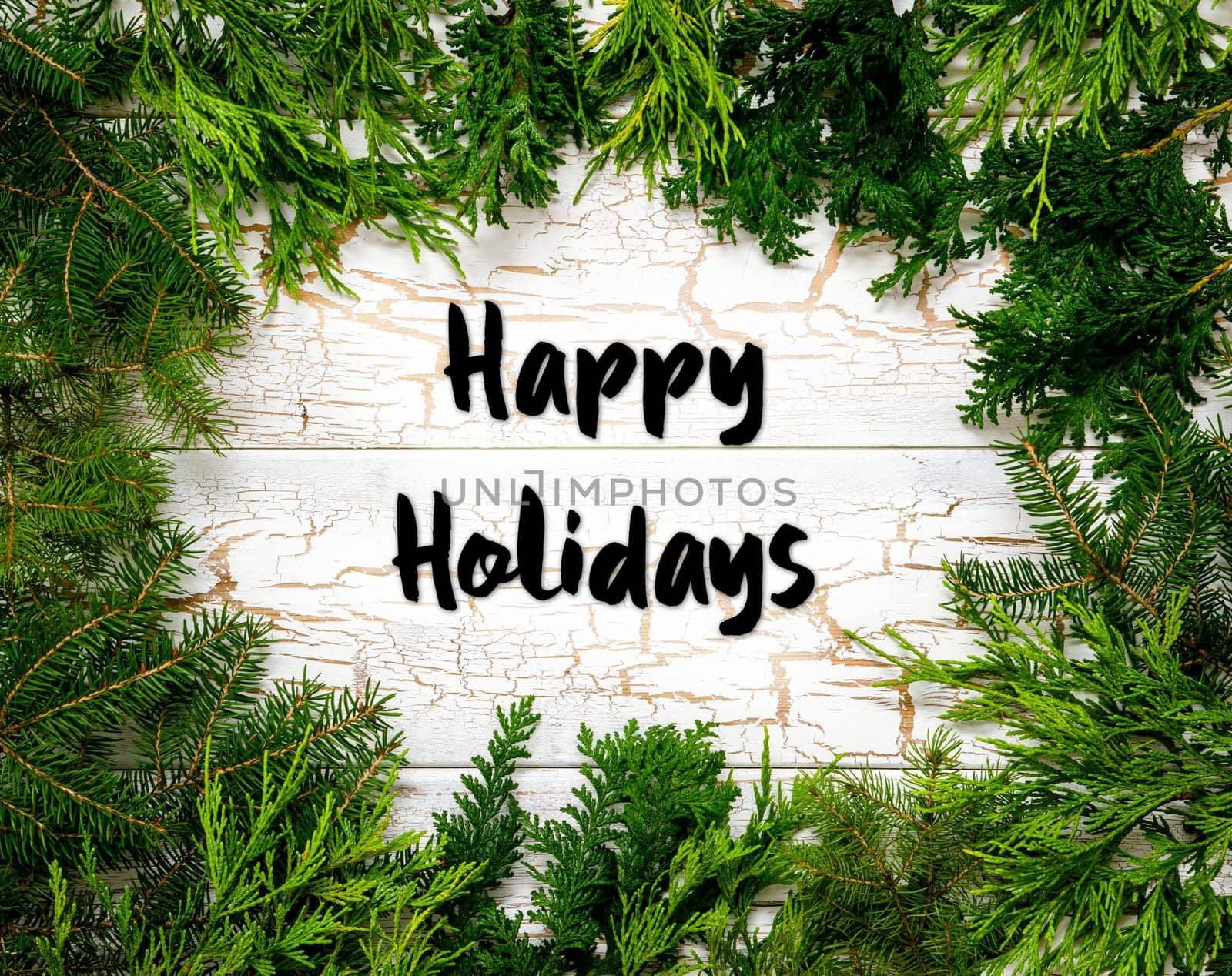Christmas Card With Fir Branches And English Text Happy Holidays. White Wooden Background With Vintage Design.