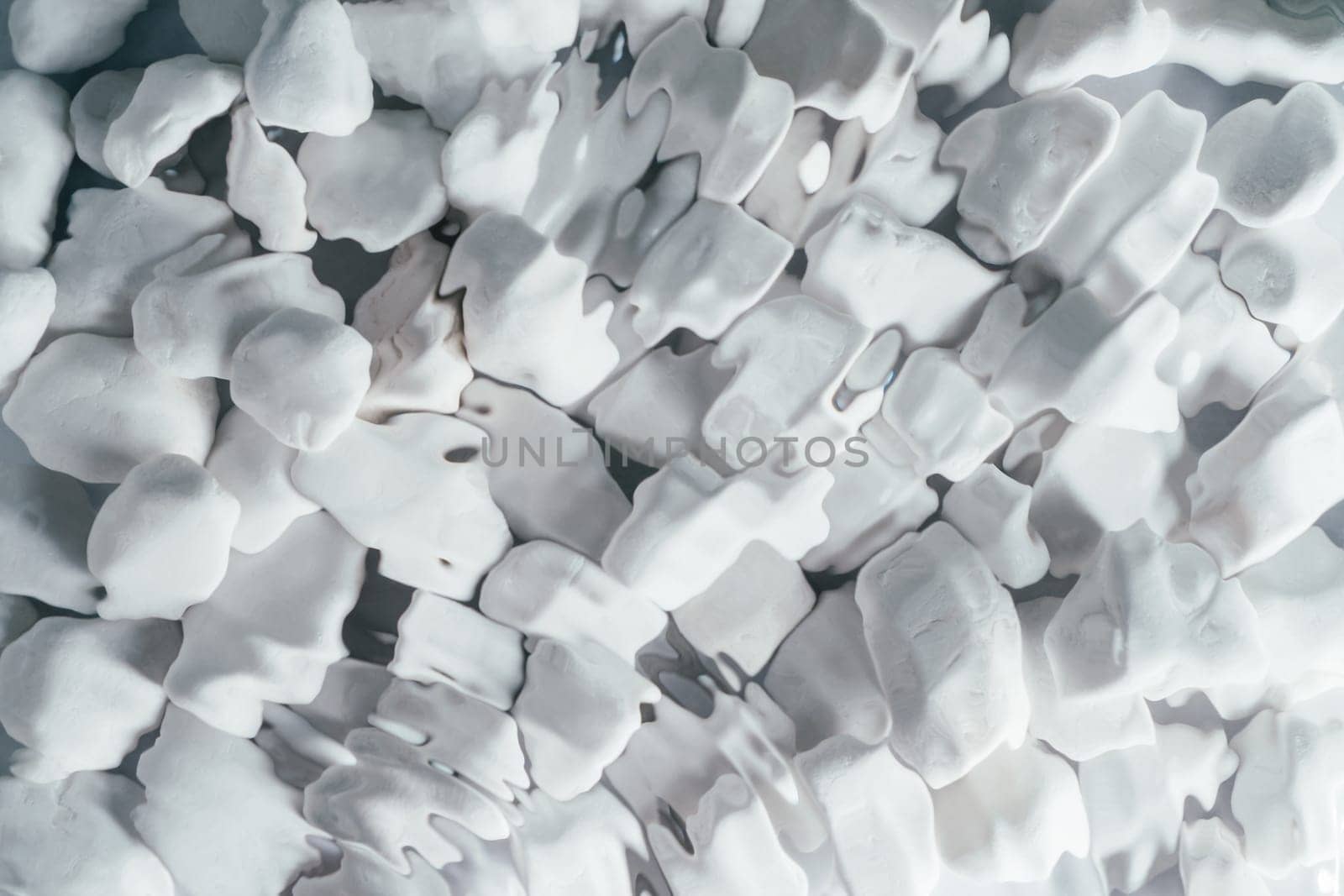 Creative background abstract image of medium-sized white rounded smooth pebble stone under transparent fresh water with flecks and waves. Backdrop stone pattern surface. Copy space. Top view, flat lay