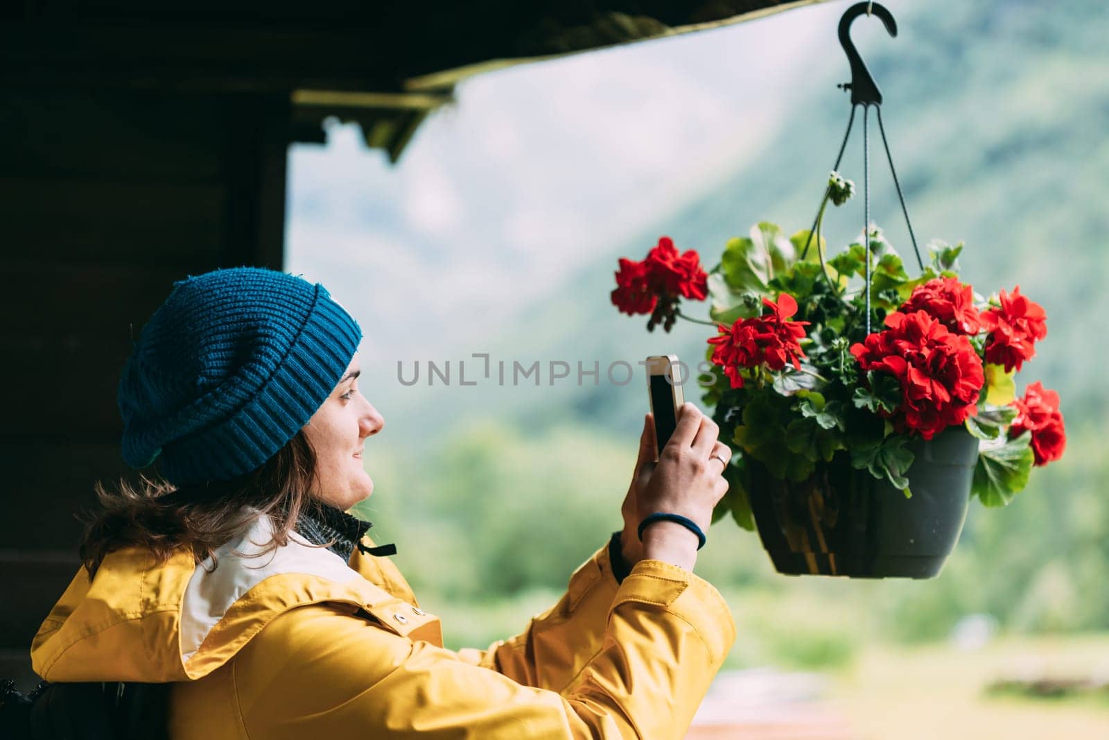Young Woman Tourist Lady Photographs A Hanging Flower Pot On Phone.