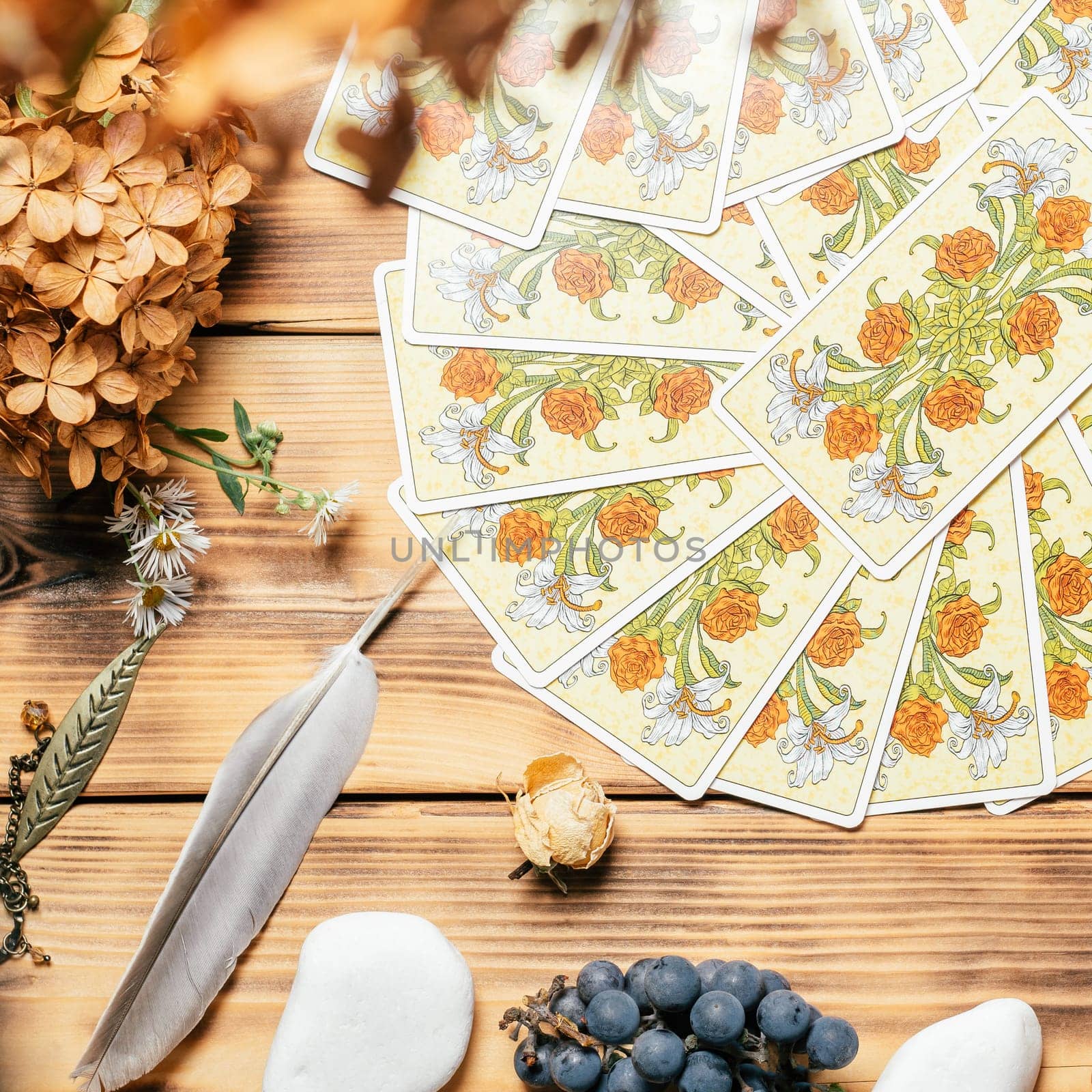 Tarot cards fanned face down on wooden surface with stones, autumn plants and accessories. Top view. Minsk, Belarus, 11.10.2021