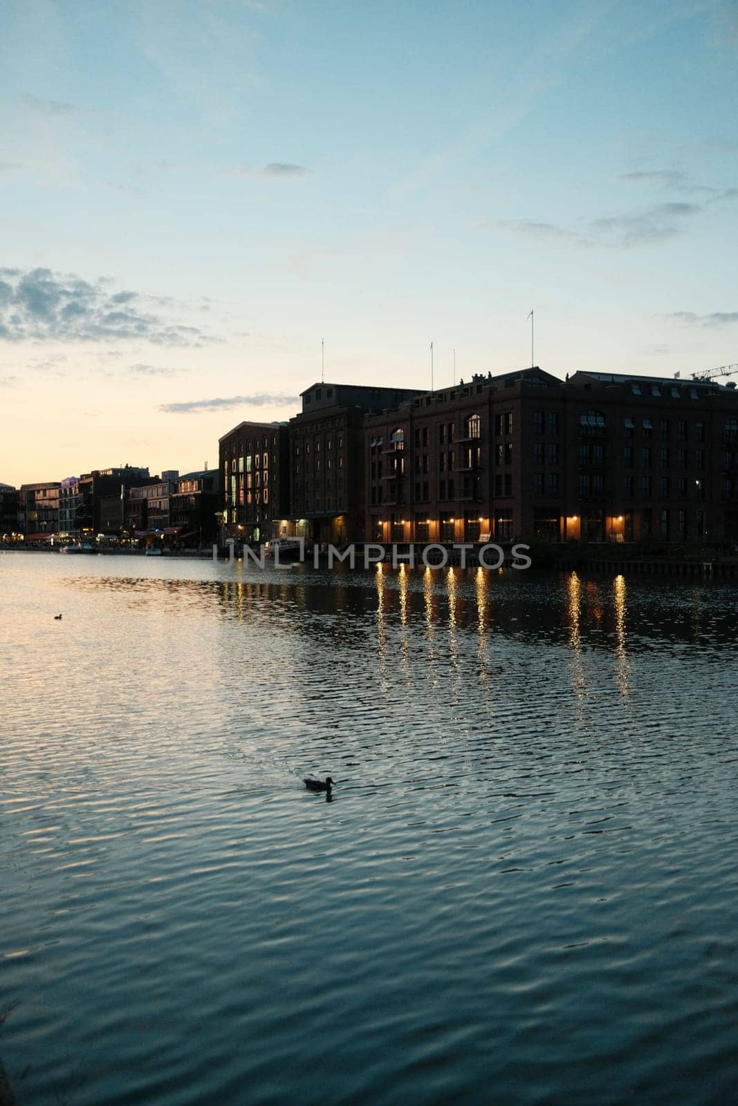 Vertical shot of an old brick building illuminated at sunset in the harbor of Munster, Germany