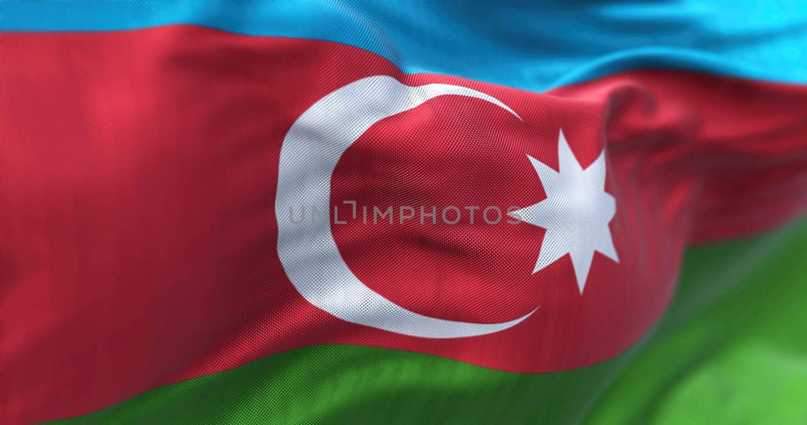 Close-up view of the Azerbaijan national flag waving in the wind. Azerbaijan is a country located at the boundary of Europe and Asia. Fabric textured background. Selective focus