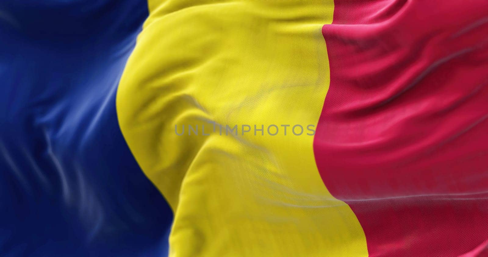 Close-up view of the Chad national flag waving in the wind. The Republic of Chad is a country at the crossroads of North and Central Africa. Fabric textured background. Selective focus