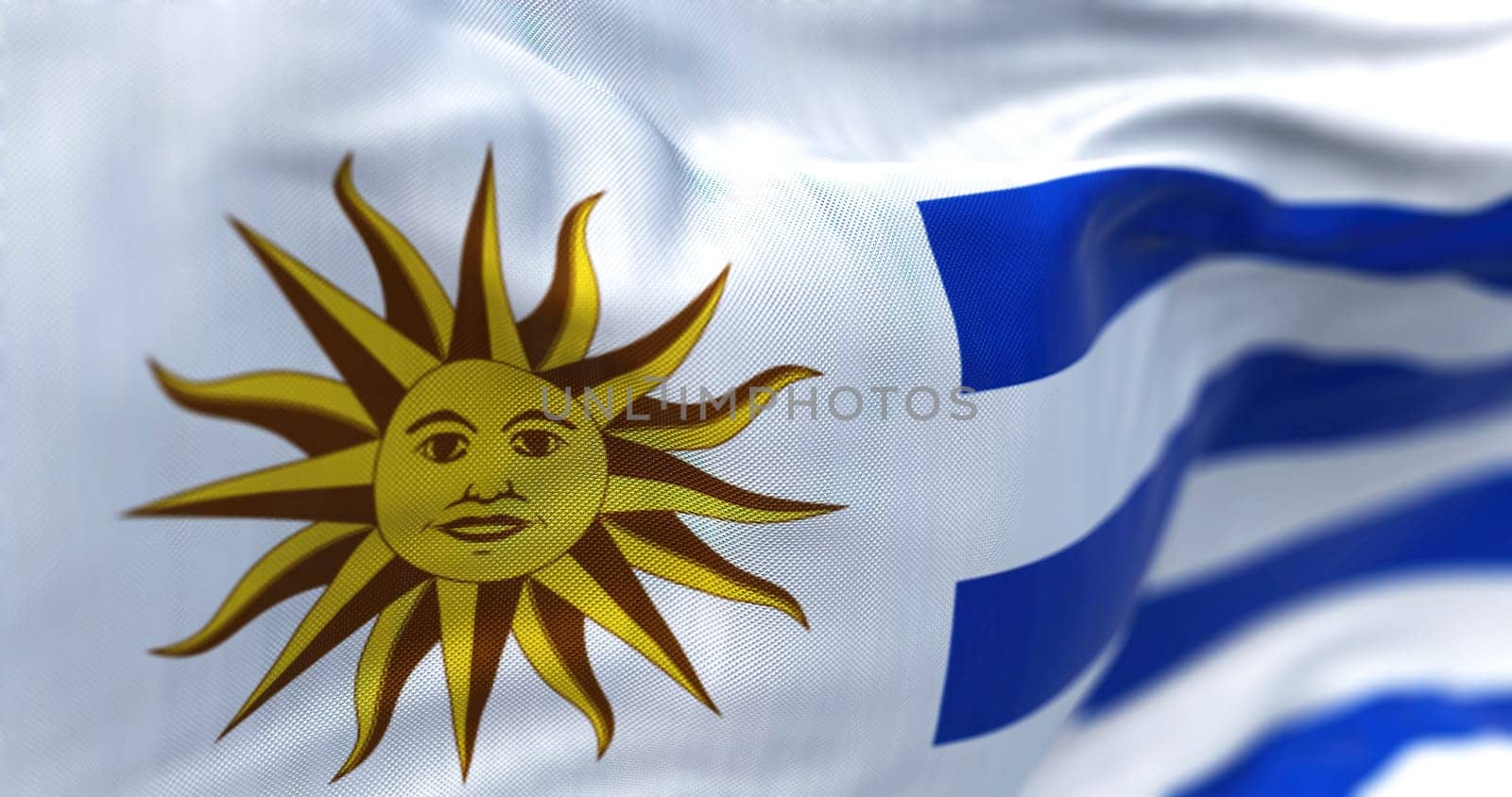 Close-up view of Uruguay national flag waving in the wind. The Oriental Republic of Uruguay is a country in South America. Fabric textured background. Selective focus