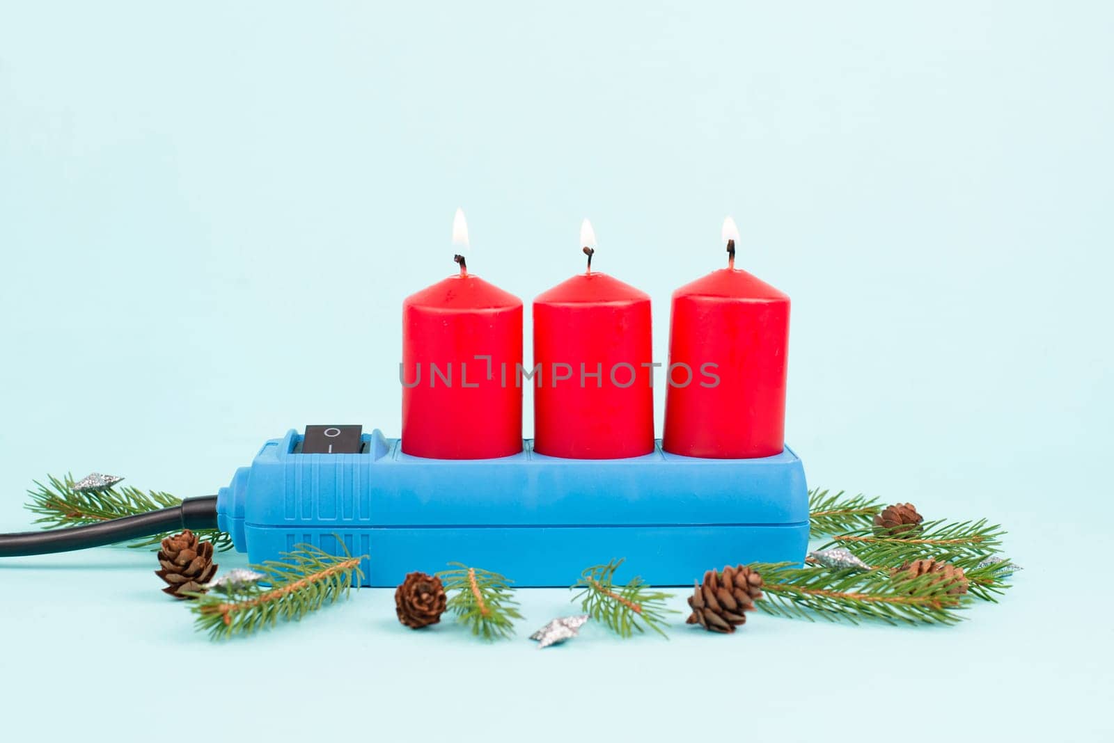 Red christmas candles in a socket, expensive electricity costs, blackout risk in Germany, cold winter with rationing