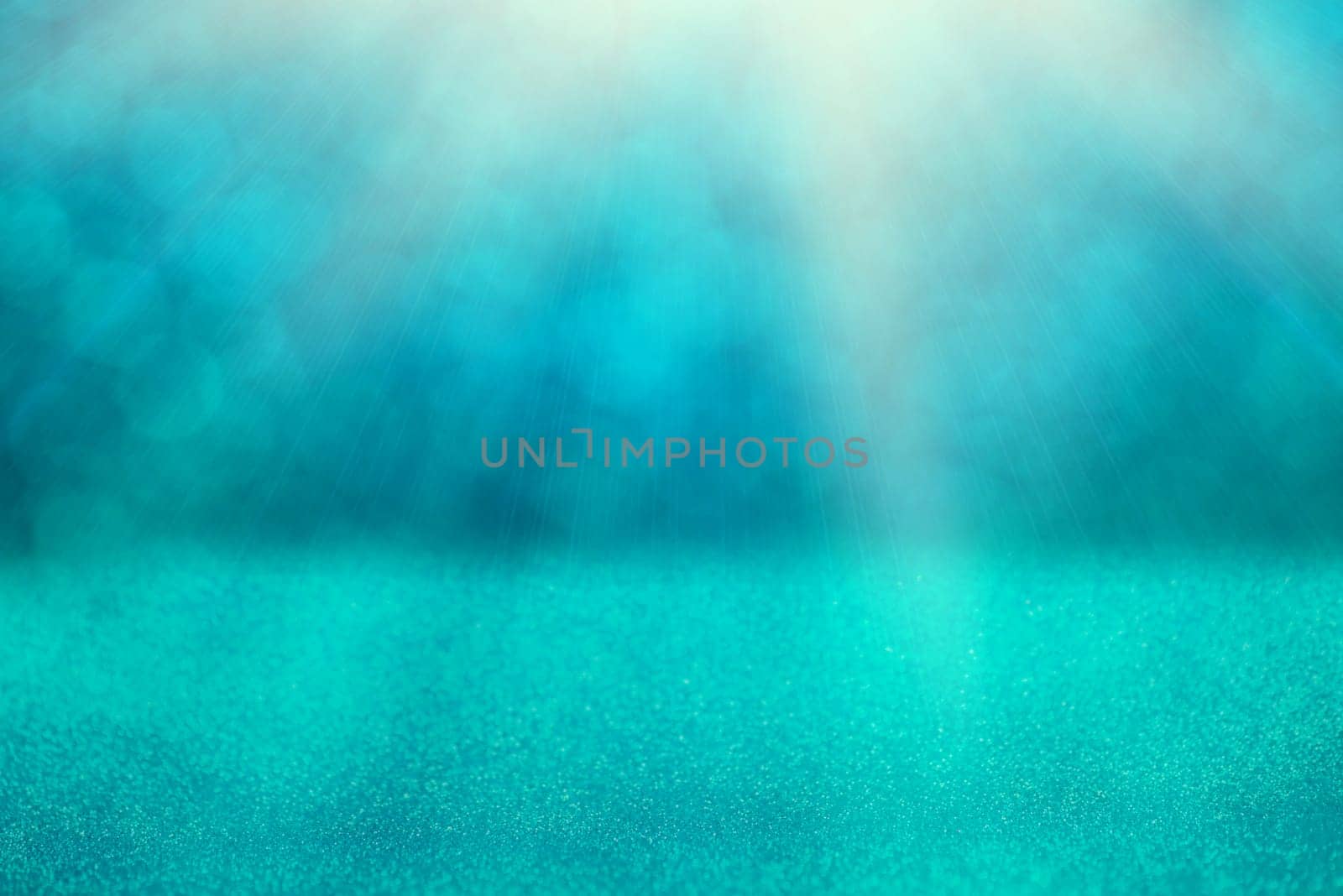 Blue bokeh background for christmas, defocused round lights and sunbeams, flare overlay