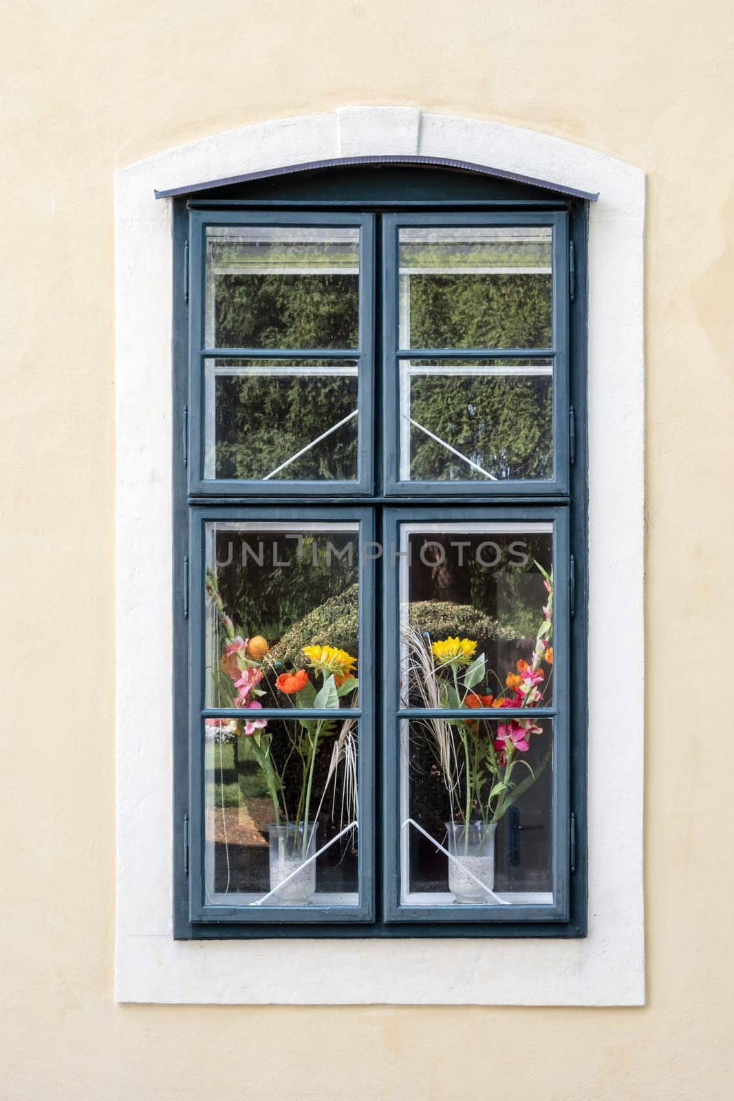 Window of a romantic and colorful house with flower pots.