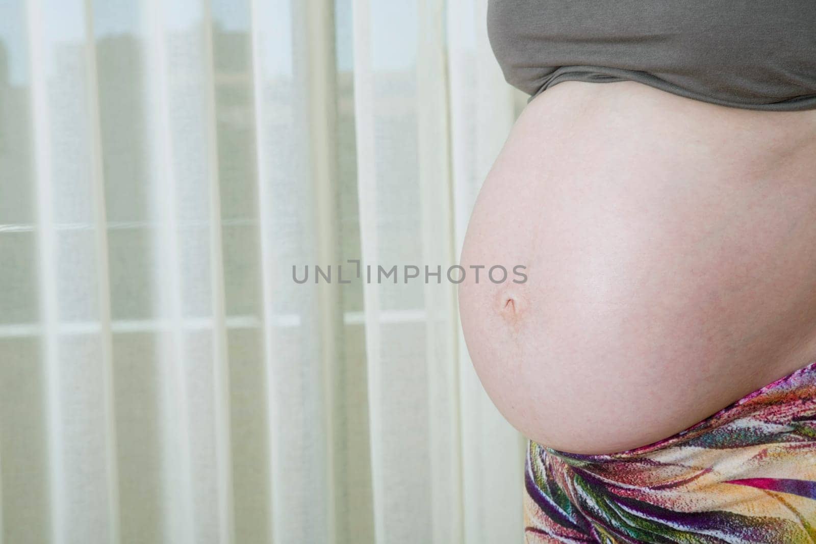 Closeup of pregnant woman at home