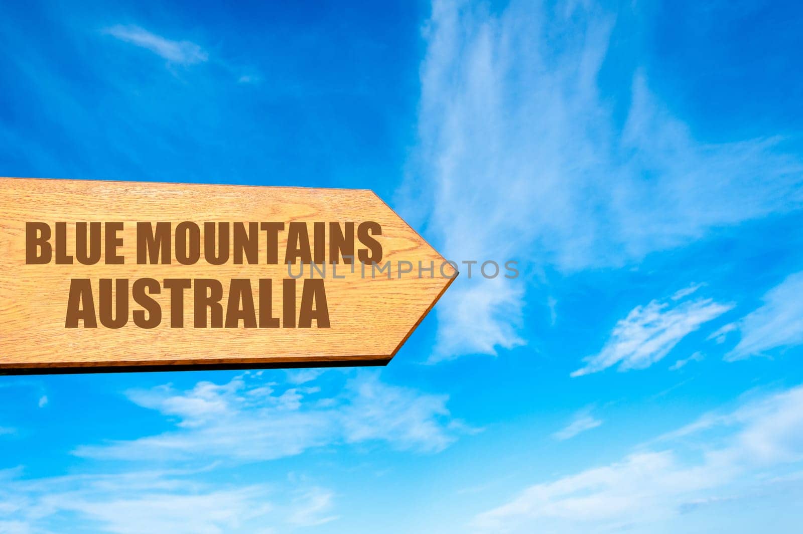 Wooden arrow sign pointing destination BLUE MOUNTAINS, AUSTRALIA  against clear blue sky with copy space available. Travel destination concept  image