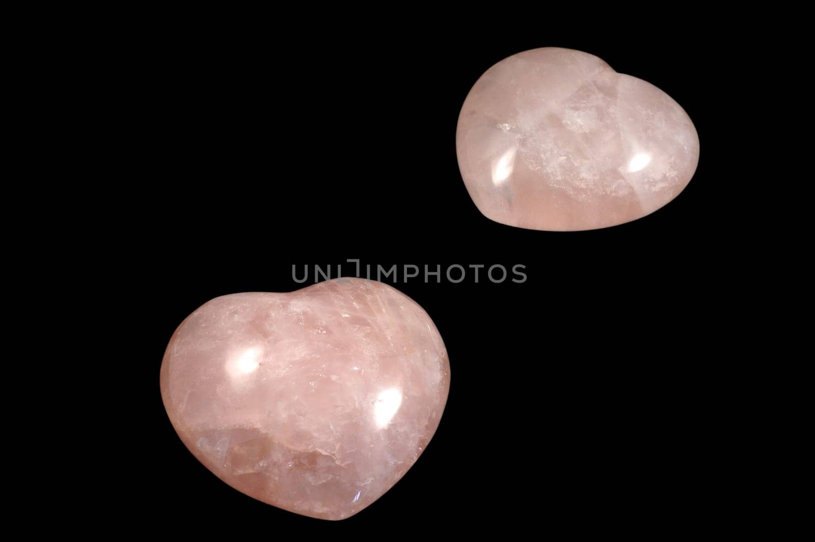 Two pink stoned hearts isolated over black