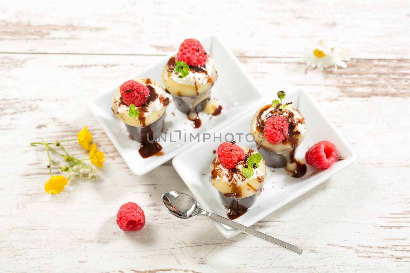Chocolate cups with vanilla pudding,cream and raspberries