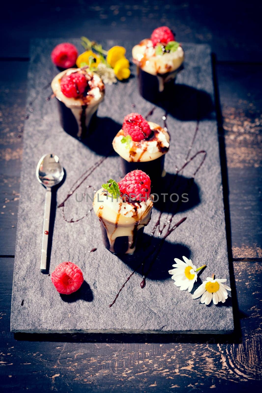 Chocolate cups with vanilla pudding,cream and raspberries