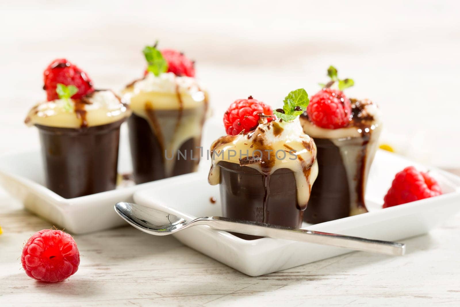 Chocolate cups with vanilla pudding,cream and raspberries