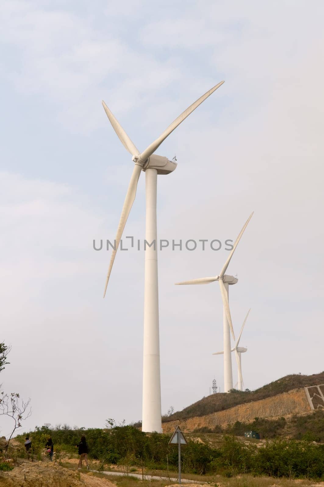 White electrical power generating wind turbines on rolling hills
