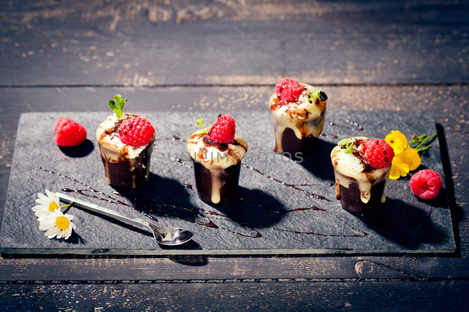 Chocolate cups with vanilla pudding,cream and raspberries