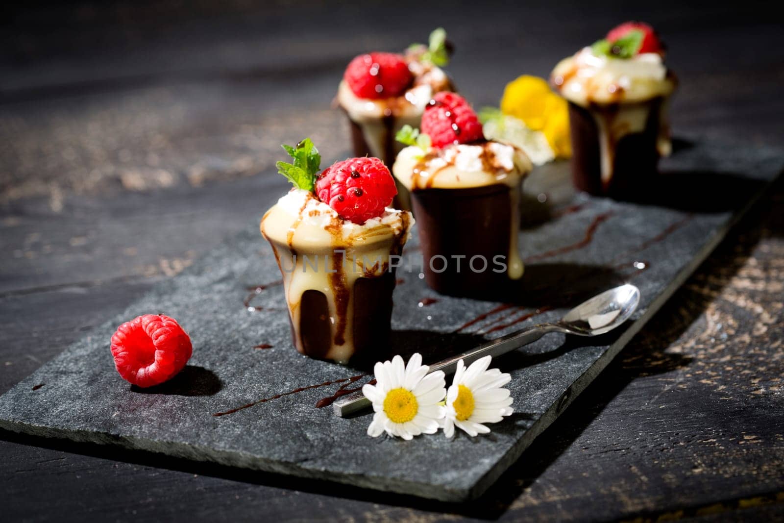 Chocolate cups with vanilla pudding,cream and raspberries