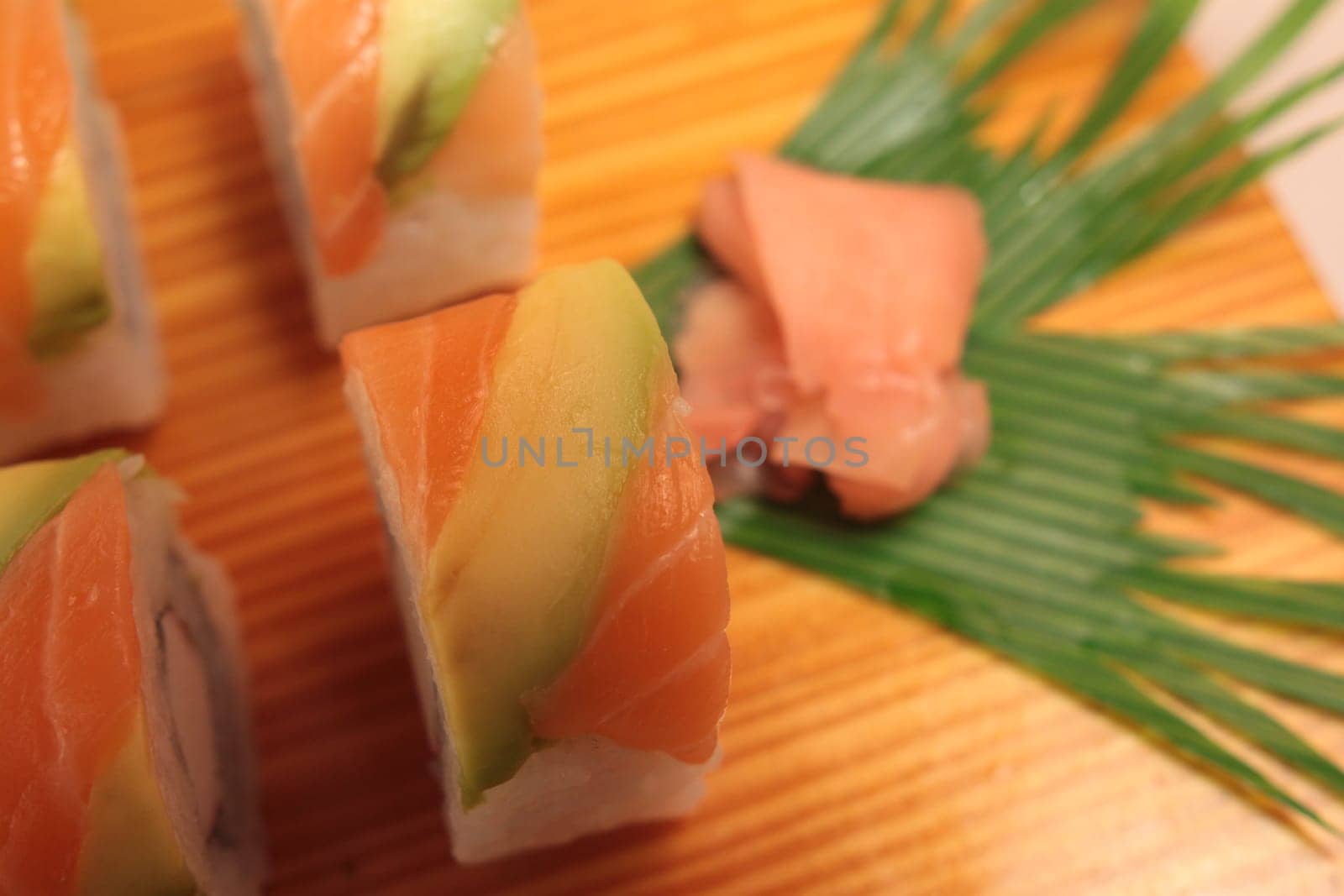 sushi with salmon and avocado on wooden plate