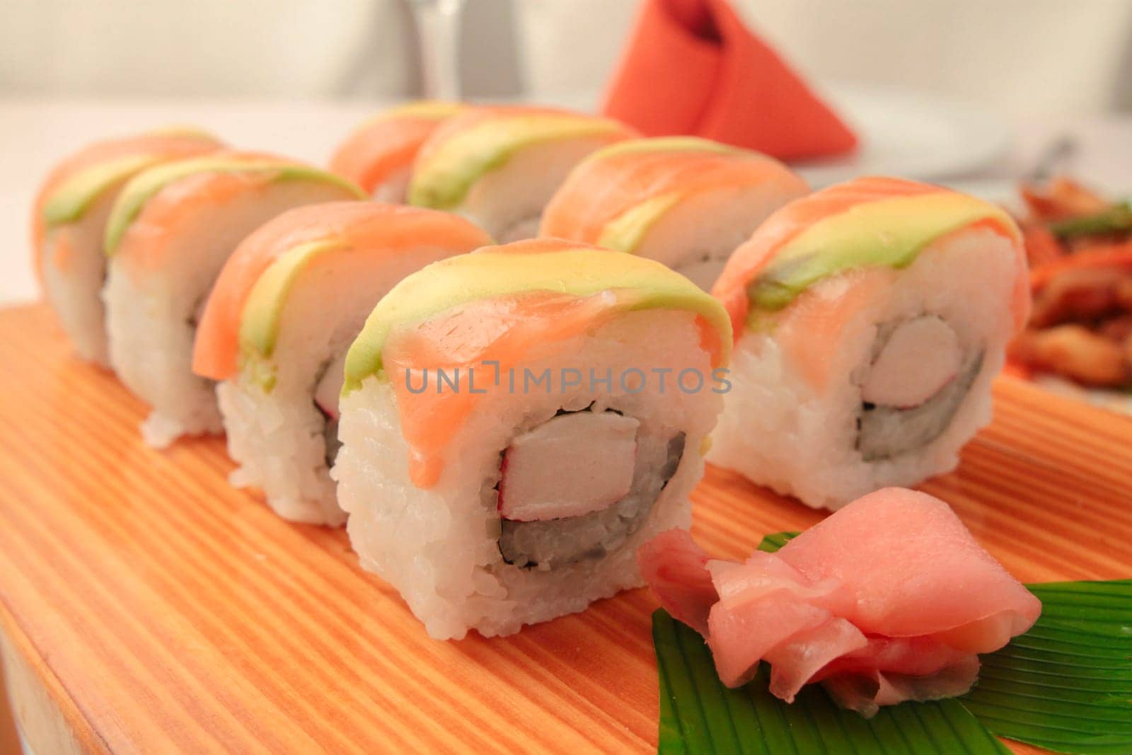 sushi with salmon and avocado on wooden plate