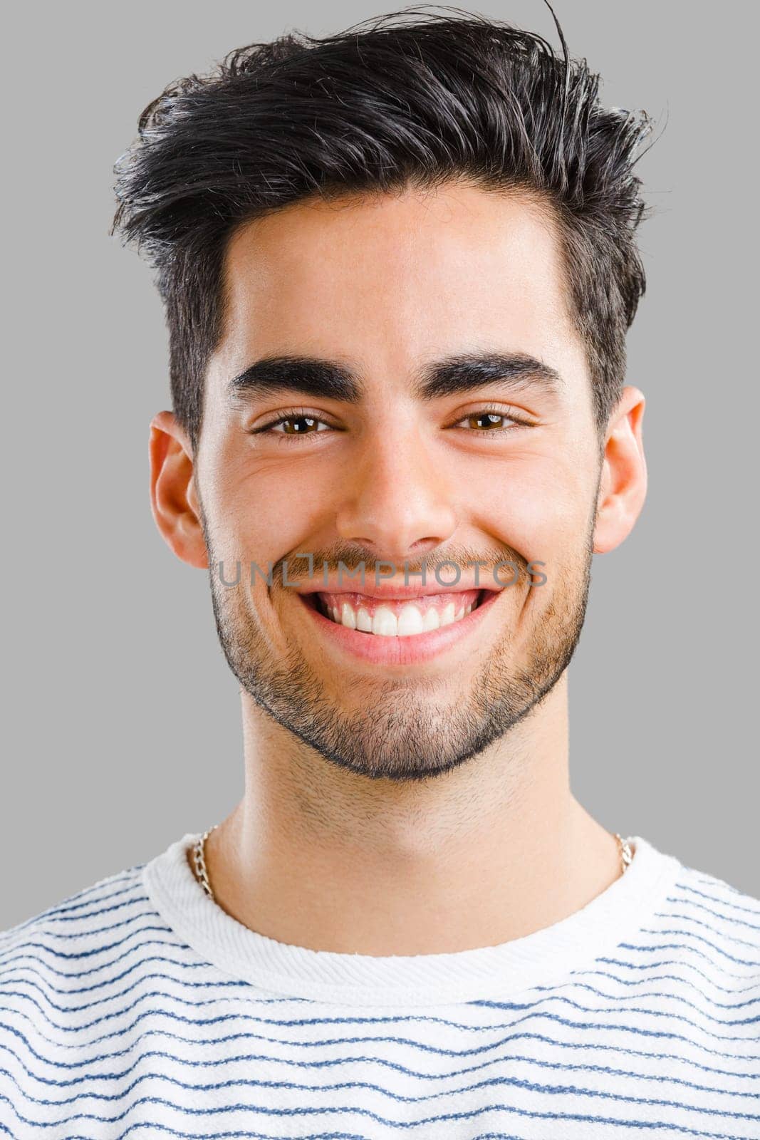 Portrait of happy handsome young man looking through his hands