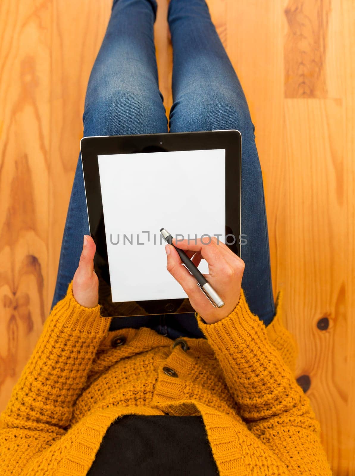 Beautiful woman sitting on the floor working with a tablet