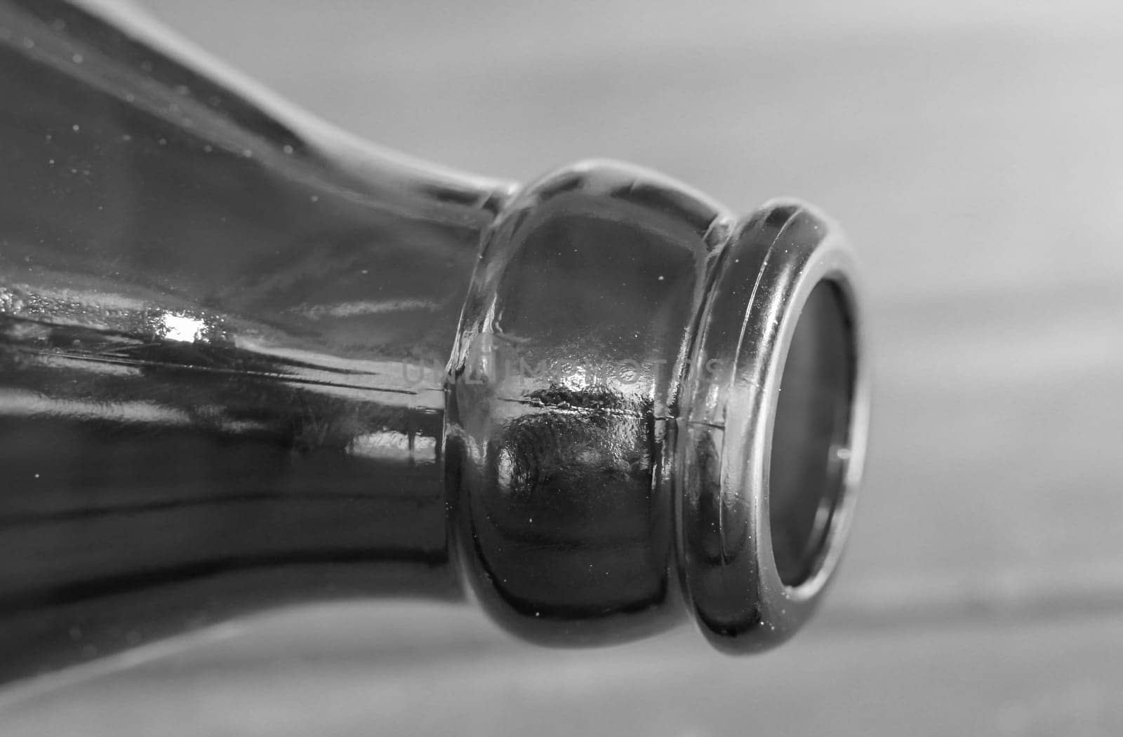 A close-up of a neck of a glass bottle for beverages.