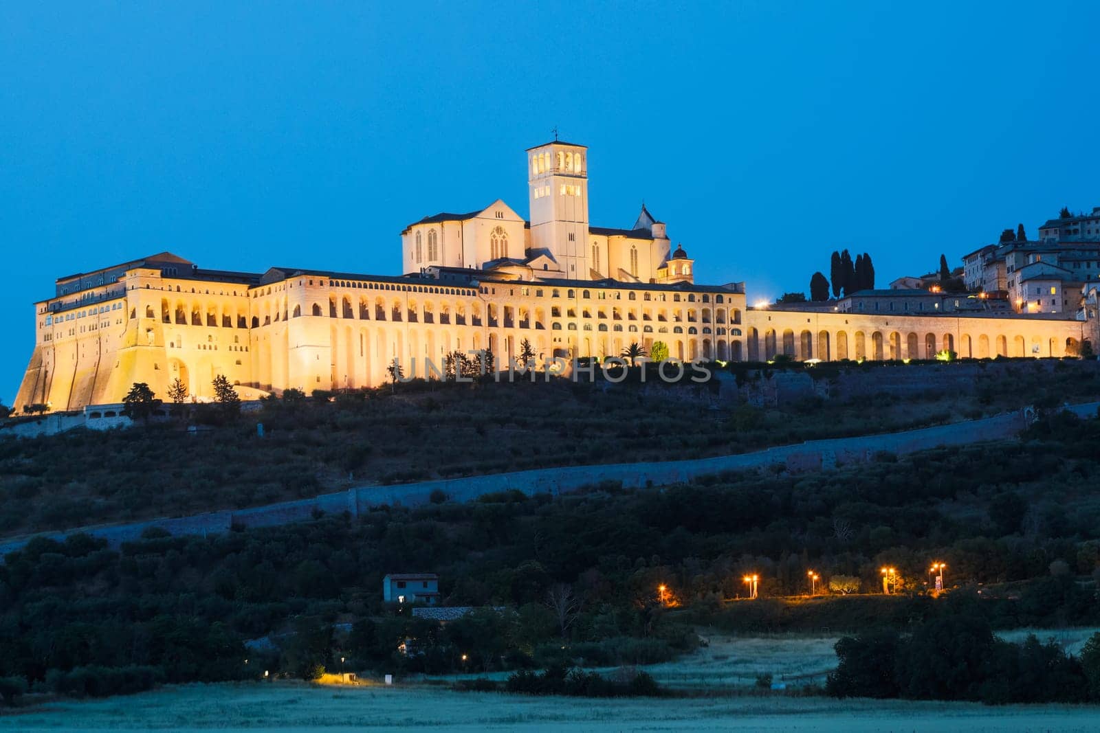 Assisi Basilica by night in Umbria region, Italy. The town is famous for the most important Italian St. Francis Basilica (Basilica di San Francesco)