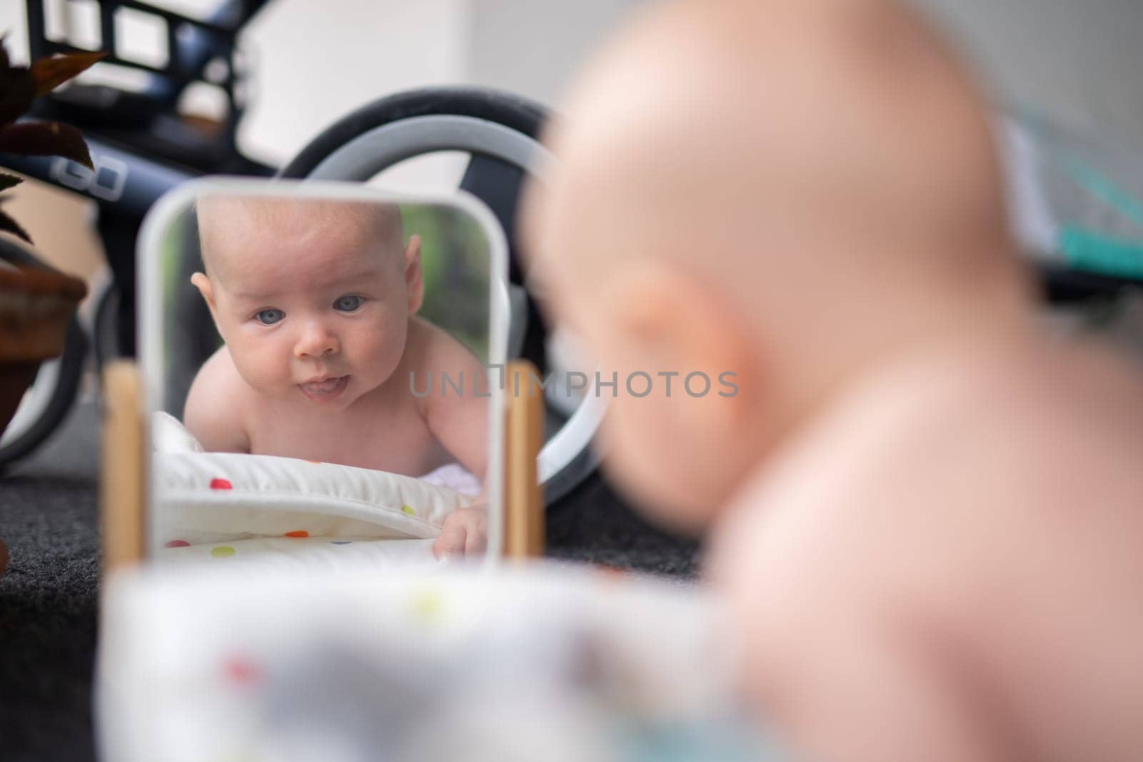 Beautiful shot of a cute baby boy looking at his reflection in the mirror
