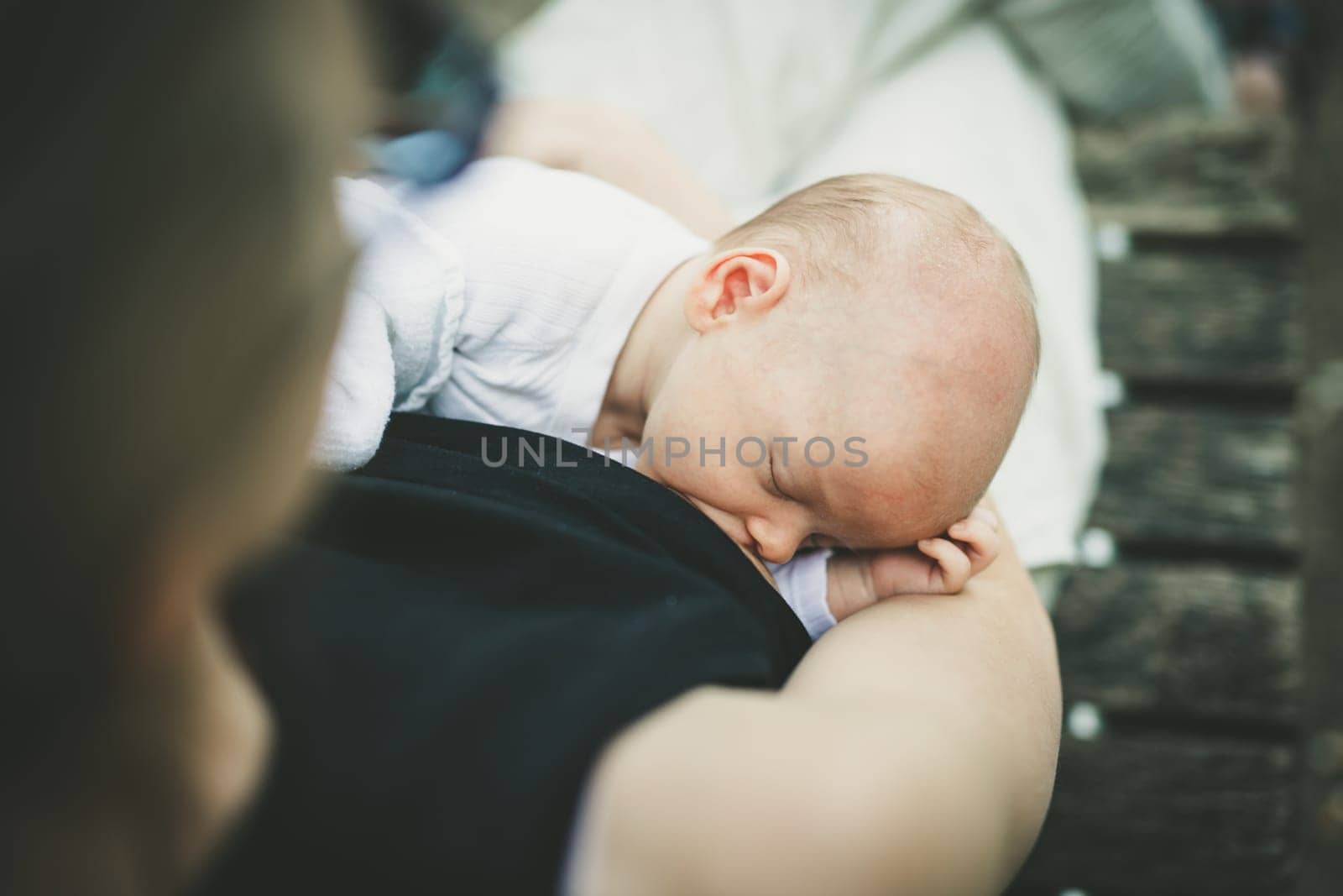 Mother breast feeding and hugging her baby boy outdoors