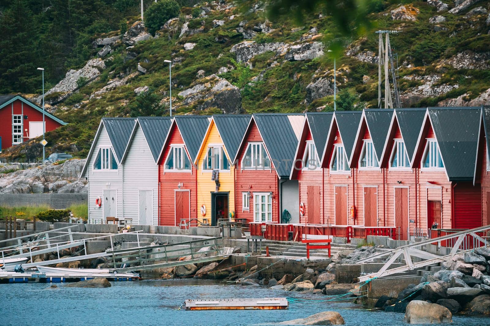 Alnes, Godoya, Norway. Red And Yellow Colorful Wooden Docks In Summer Day. Godoy Island Near Alesund Town.