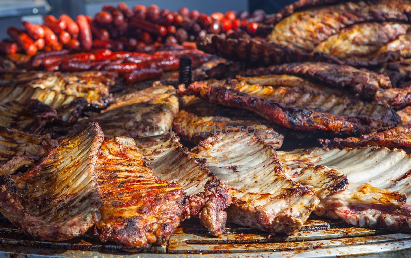 Huge circular grill loaded with pork ribs. Selective focus