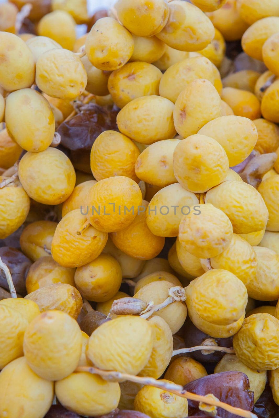 Bunches of round yellow dates, barhi variety. Displayed at street market stall