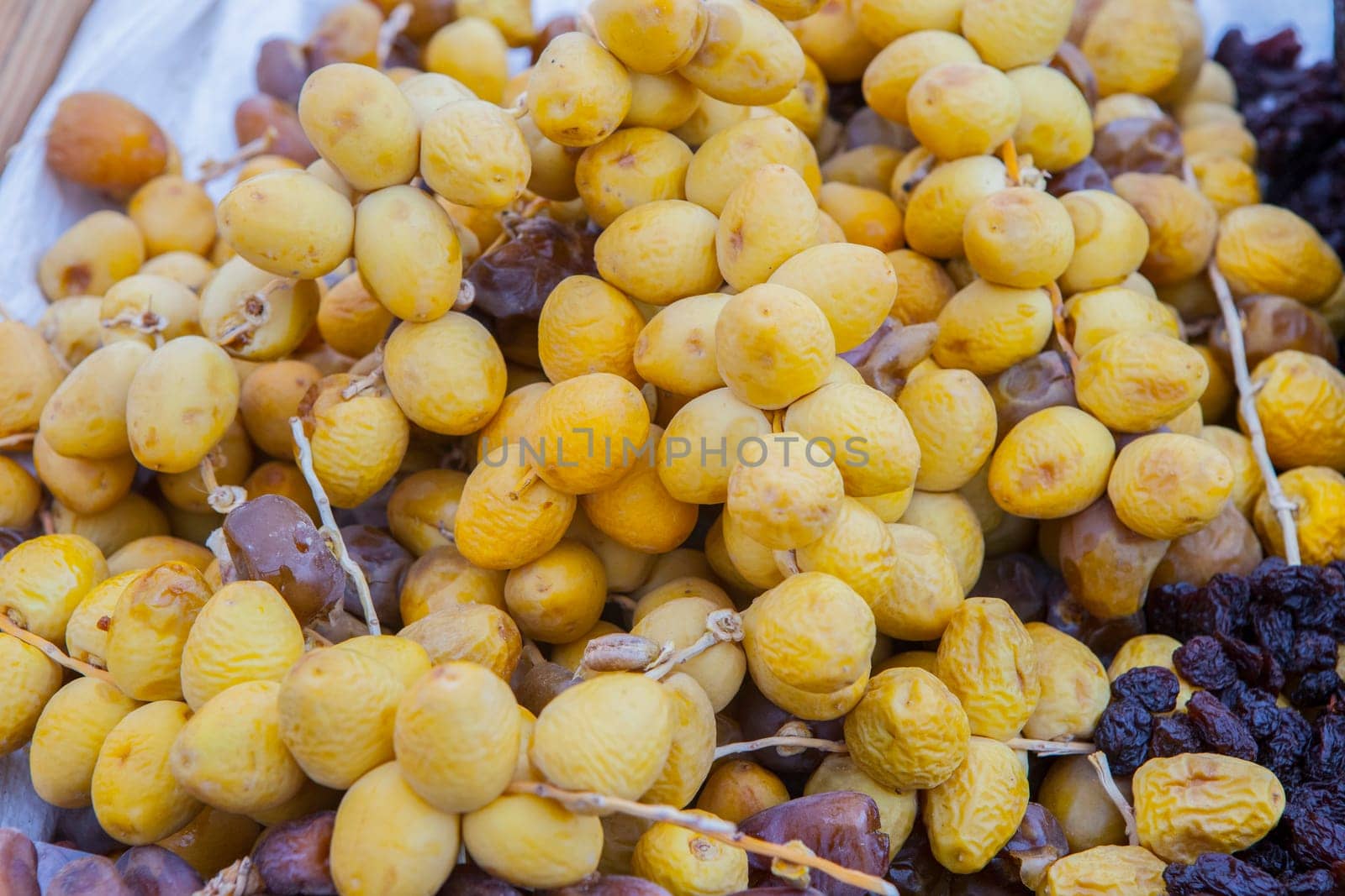 Bunches of round yellow dates, barhi variety. Displayed at street market stall