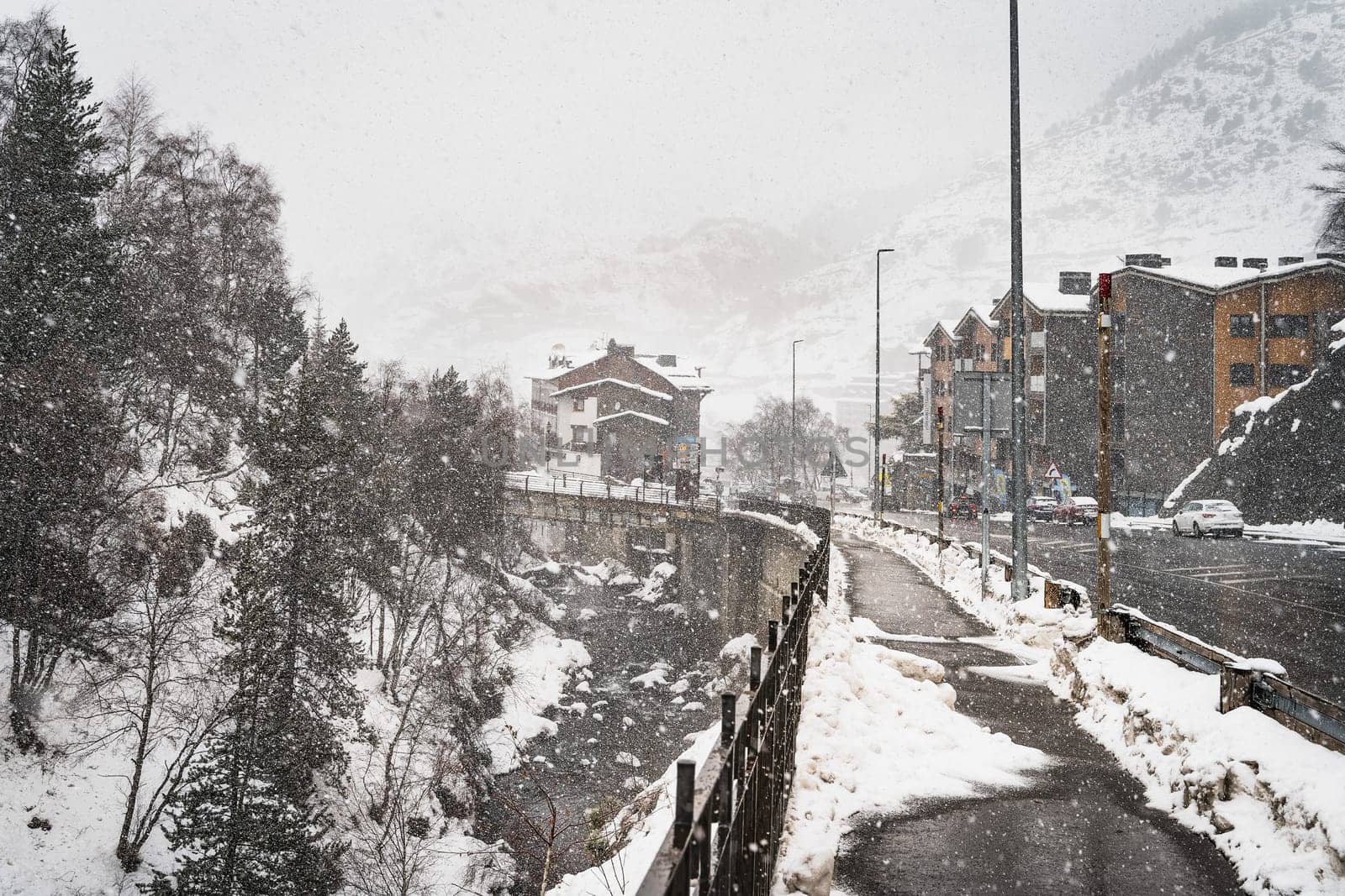 Heavy snow fall in El Tarter city. Street and sidewalk leading to the town and ski resorts in Pyrenees Mountains, Grandvalira, Andorra