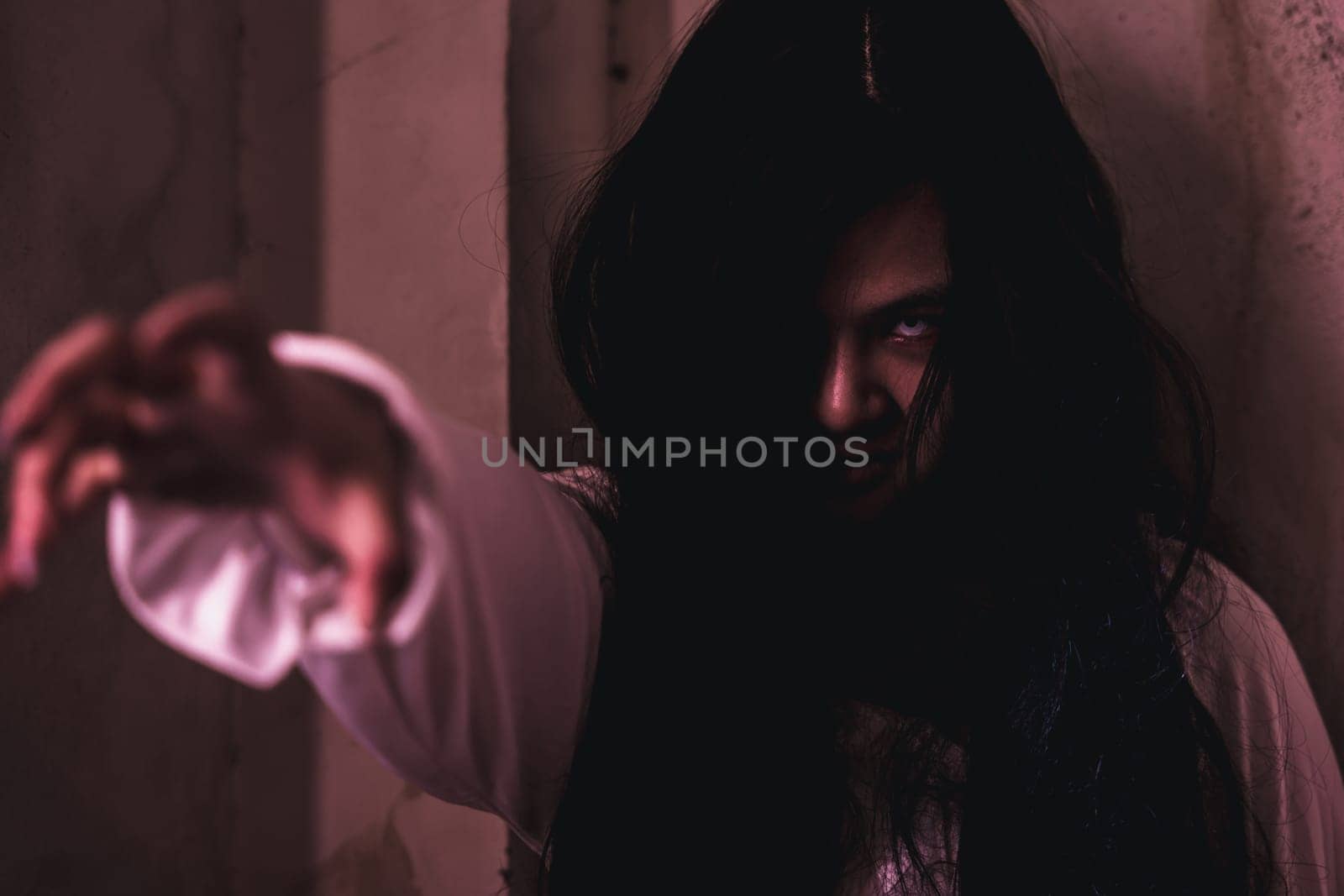 Scary ghost woman. Asian ghost or zombie horror creepy scary have hair covering face and eye reach arm out at abandoned house dark room, female makeup terror zombie face, Happy Halloween day concept
