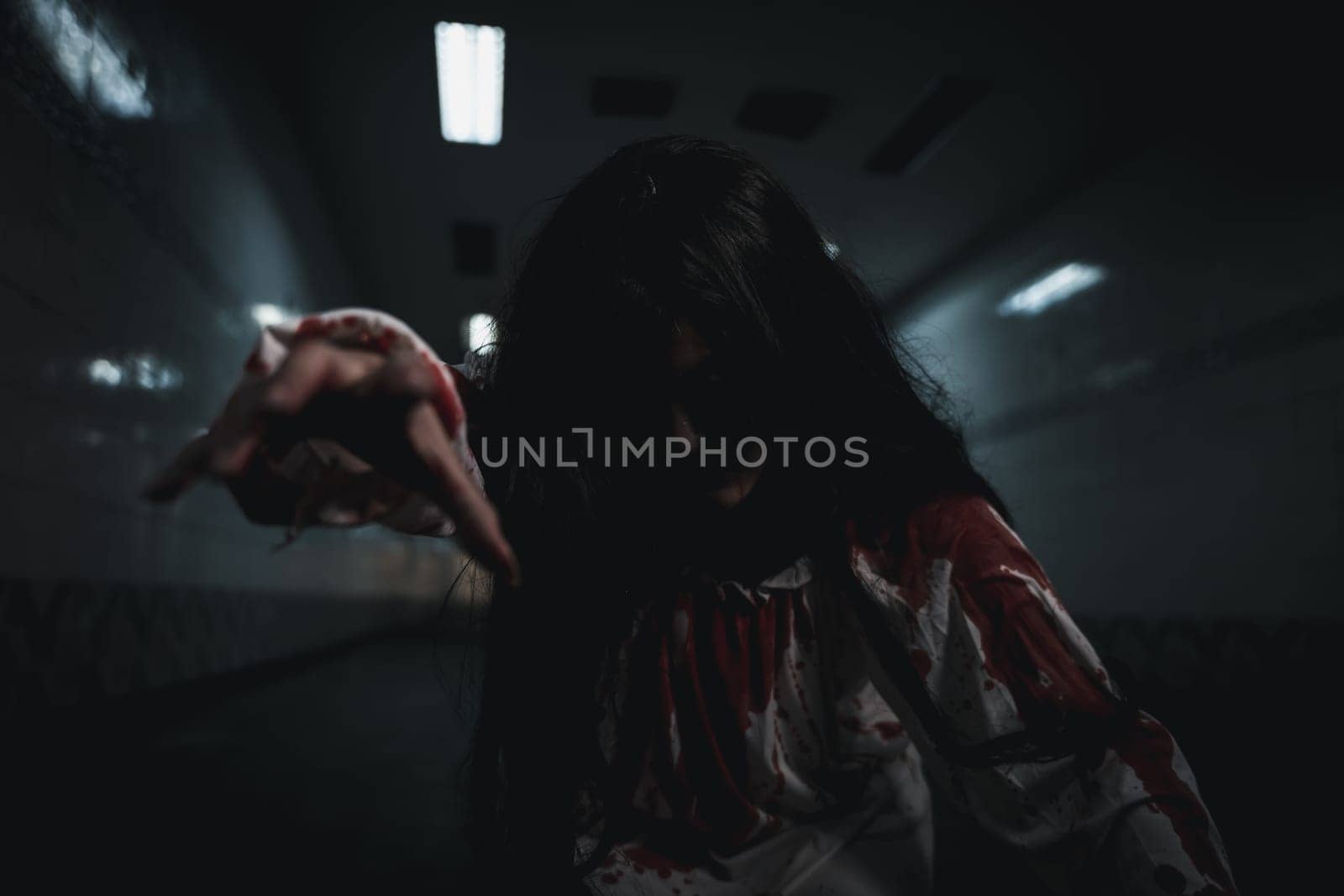 Bloody halloween makeup. Asian woman zombie with blood she death and scary at dark night in tunnel, Horror bloodthirsty ghost girl hair covering face and eye reach arm out, Happy halloween day concept