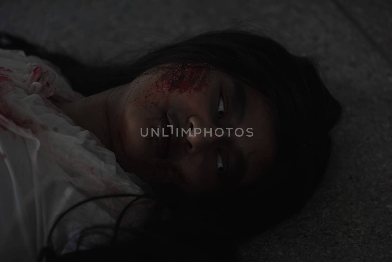 Horror evil woman ghost creepy lying dead in a dark room at house. Female zombie in blood devil is scary she haunted at the abandoned building, Happy Halloween festival day concept