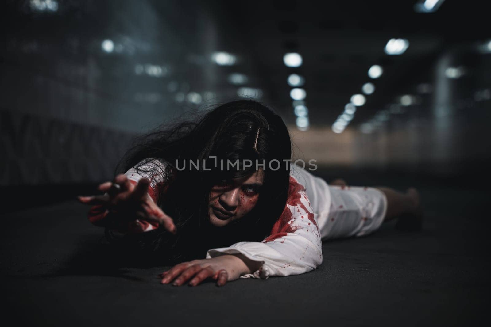 Horror Asian woman zombie with blood creepy crawling move slowly creeping out, Spooky ghost tousled hair covering her face with blood in hand reach out at night, Halloween day horror concept