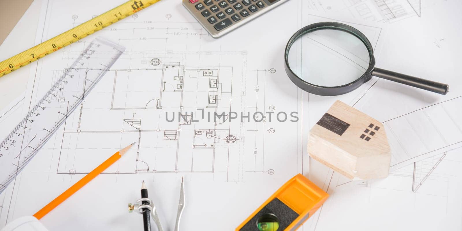 Architectural project workplace. Top view of house plan blueprint paper with repair tools on table desk at architecture office, Engineering architect design tools concept