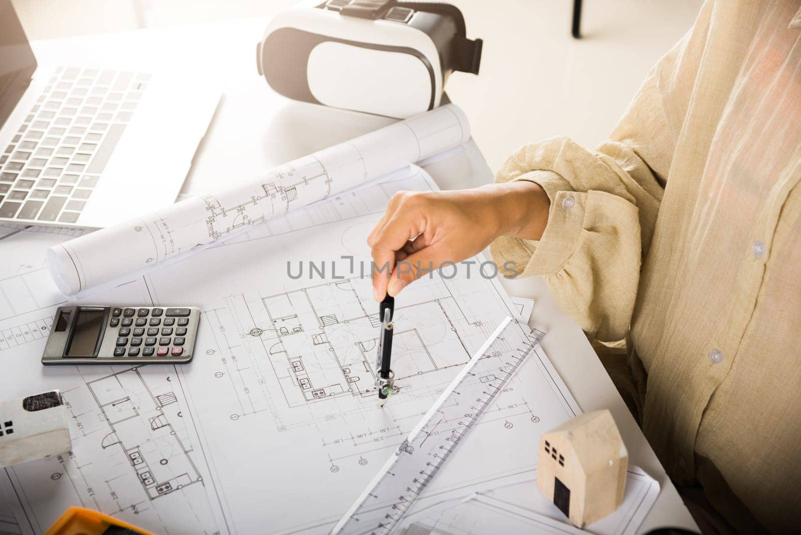 Architect interior design drawing with divider compass on house plan blueprint paper for editing on table desk at architecture office, Engineer sketching construction, Architectural project workplace