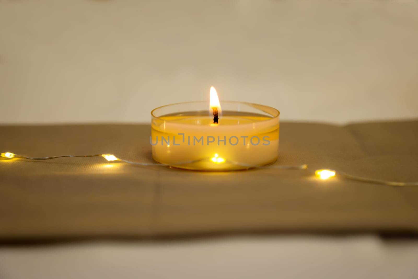 A burning tea light as a table decoration on a festively set table.