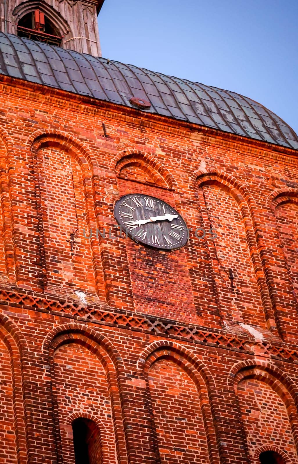 A detailed view of a church tower built of red bricks.