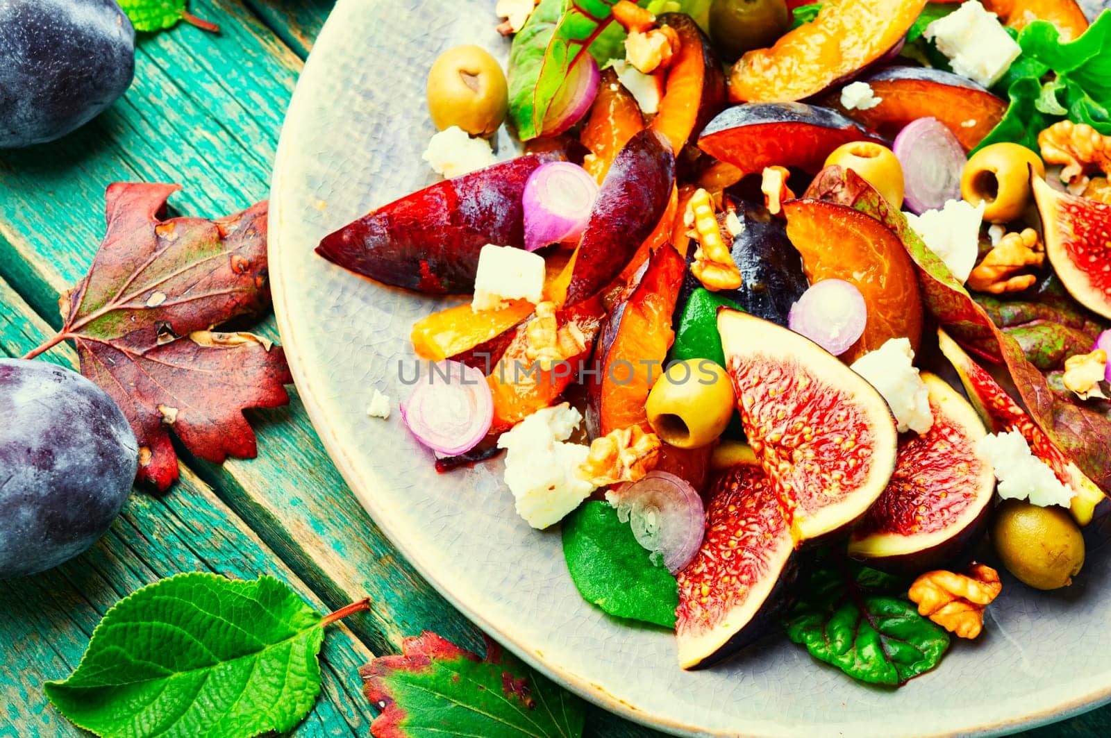 Unusual salad with figs, plums, herbs and olives. Vegetarian salad