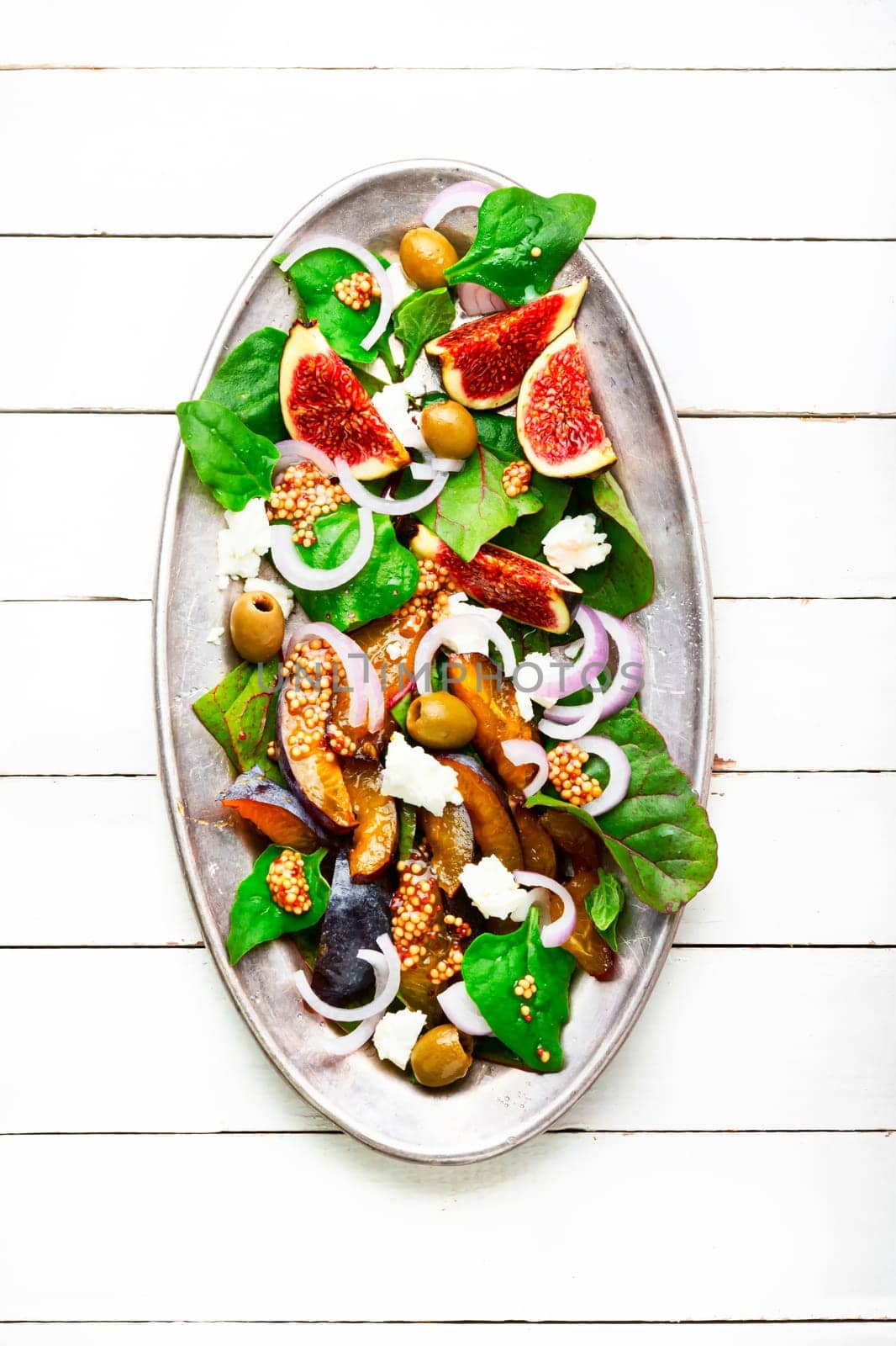 Unusual salad with figs, plums, herbs and olives. Vegetarian salad
