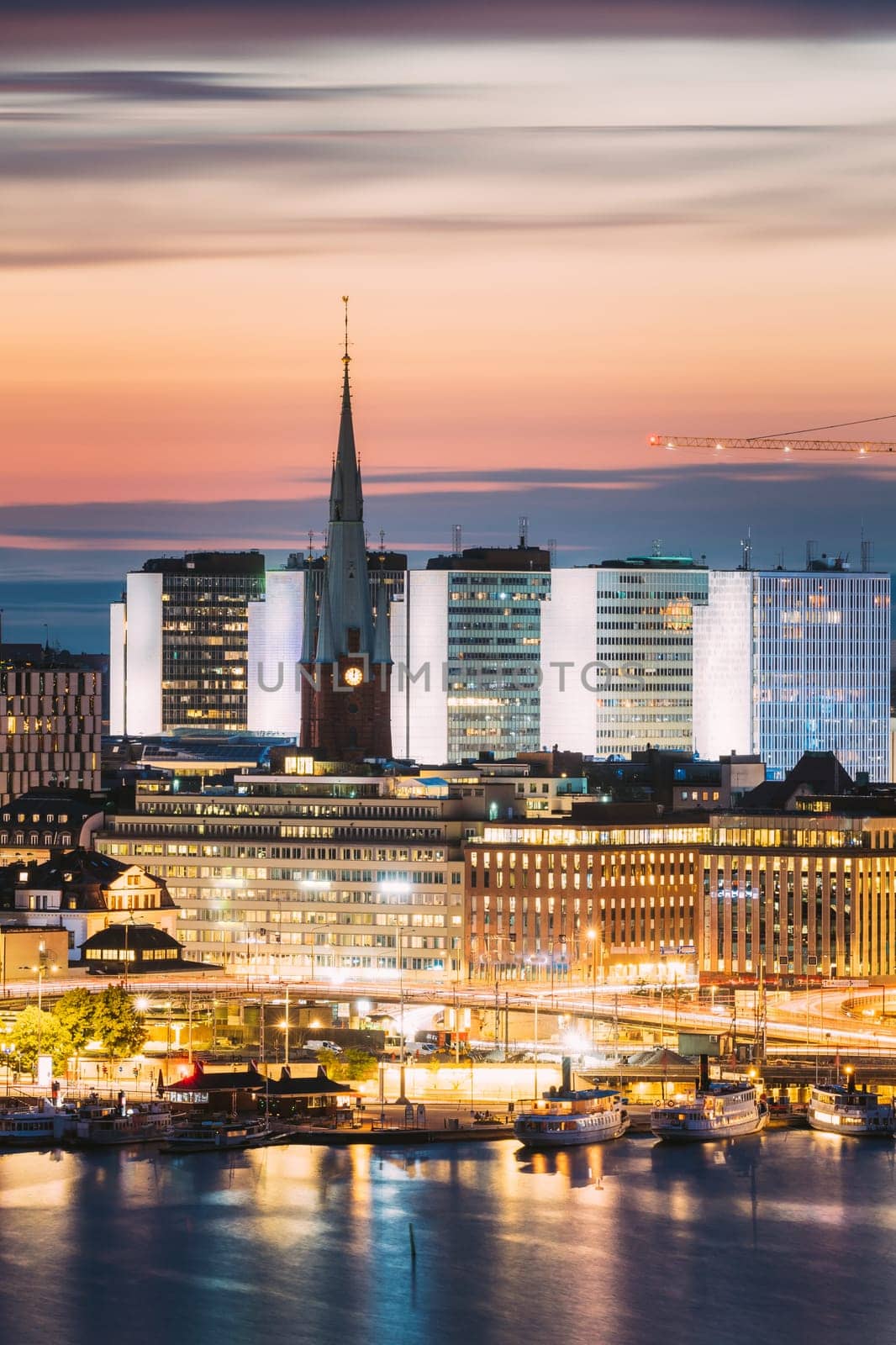 Stockholm, Sweden. View Of St. Clara Or Saint Klara Church And Houses In Twilight Dusk Lights. Evening Night Lighting.
