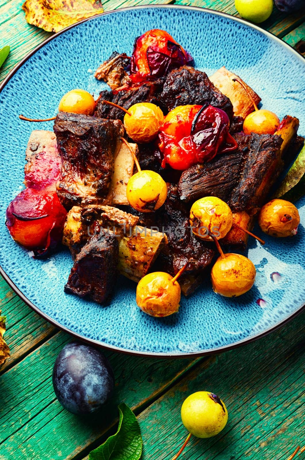 Prepared pork ribs fried with autumn fruit.Spare ribs on the plate