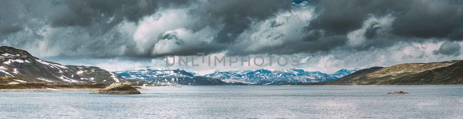 Oppland, Tyin Lake, Norway. Stones On Coast Of Beautiful Lake Tyin In Summer Cloudy Day. Norwegian Nature. panorama, panoramic view