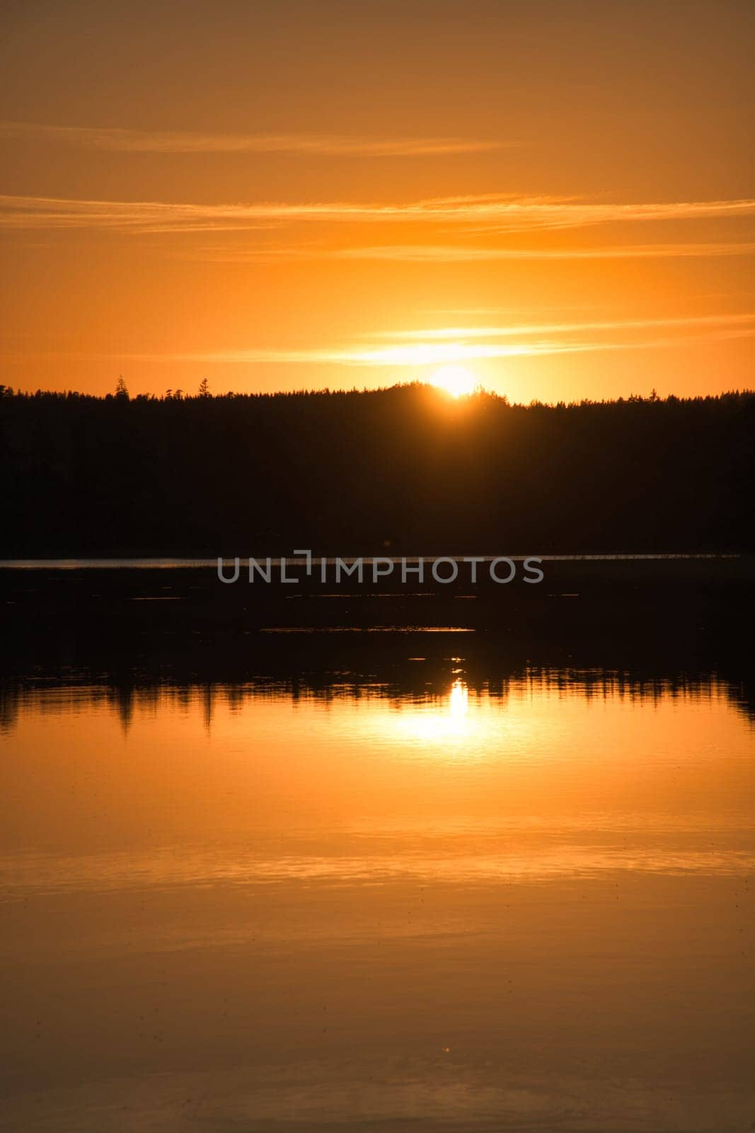 Sunset with reflection on a Swedish lake in Smalland. Romantic evening mood. Landscape shot from Scandinavia in nature