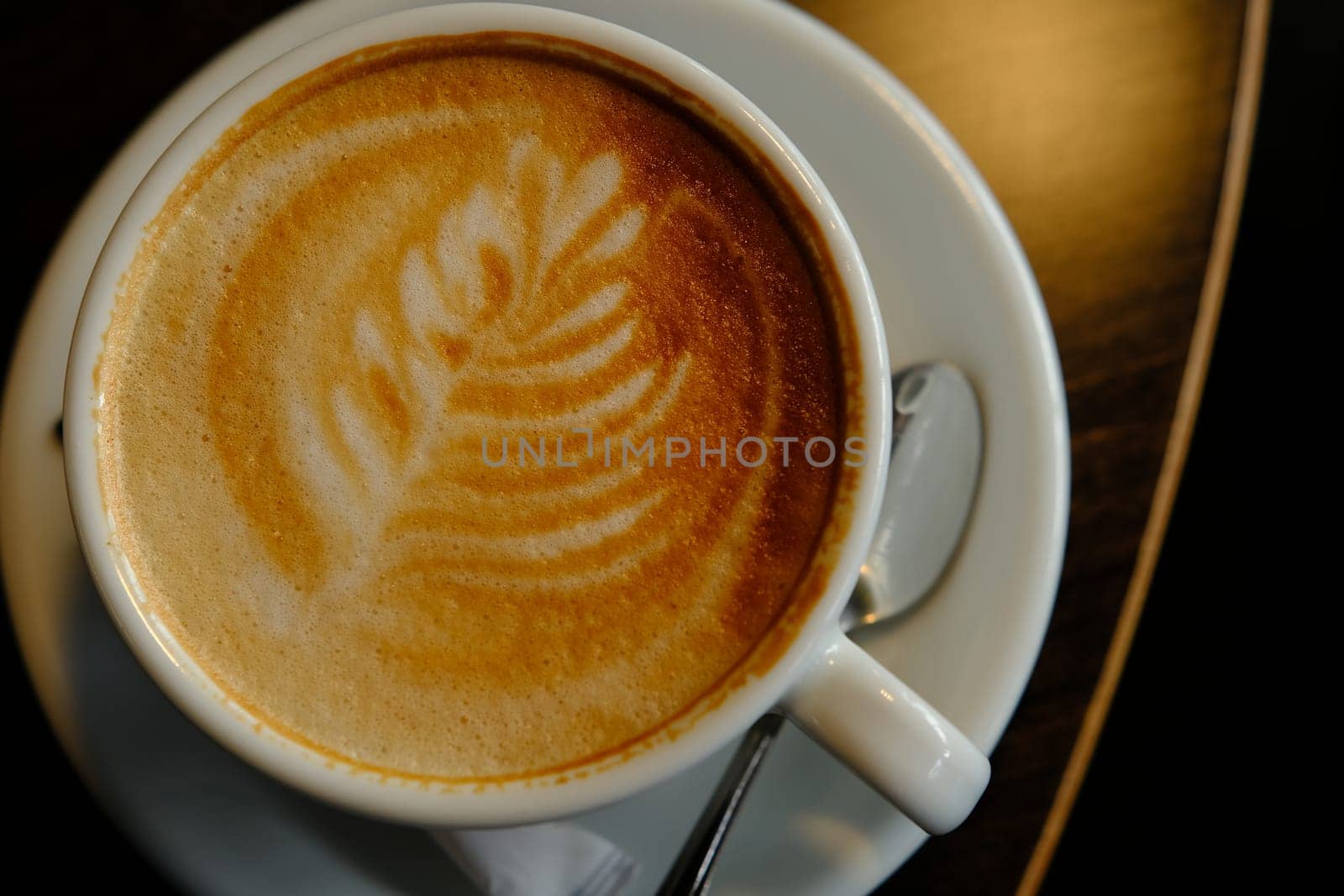 White cup of espresso coffee close up with beautiful tree patern from milk foam in the cup.